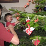 Ellen kigger på at far pynter juletræ.